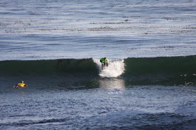 The surfer is holds the rails (outside edges of the board) and with head up to see where he wants to drive the surf board he will execute standing.