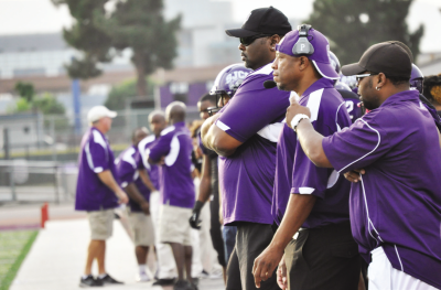 Team coaches discuss plays and strategies for the players on the sideline.