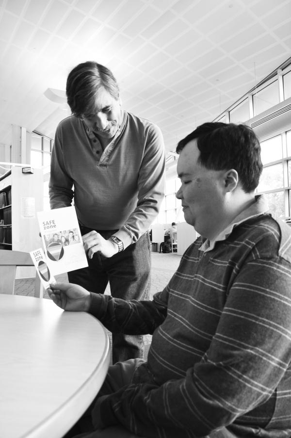 Safe Zone facilitator, Joseph King (left) discusses Lesbain, Gay, Bisexual, and Transgender program with senior librarian technician, Peter Vu (right) in the SJCC library.