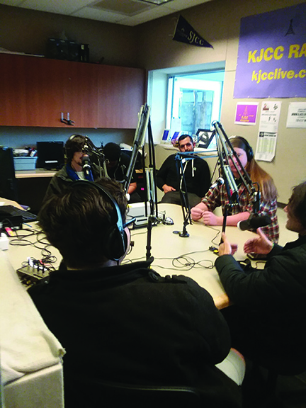 KJCC Dj and broadcasting student Jake Bergvall rehearses his public service announcement for Valentine's Day while fellow students look on.