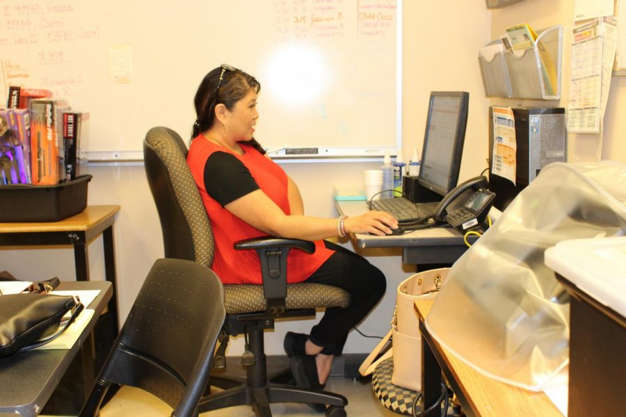 Cosmetology coordinator Gina Fontela looks up statistics in the cosmetology office Thursday, April 26.