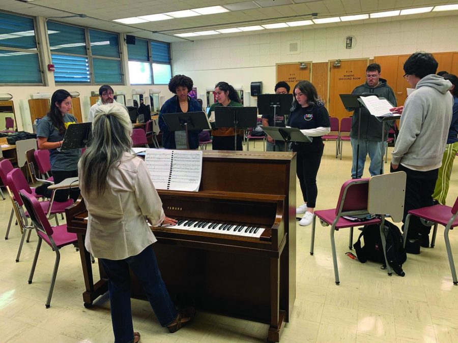 Cast members warm up for rehersal in the theatre building, Oct. 3.