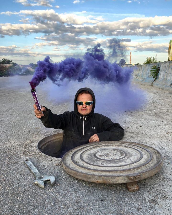 Super Sus, popular YouTuber and urban explorer, emerges from an underground vault wielding a flare billowing purple smoke.

Photo courtesy of instagram user sssuper_sus.