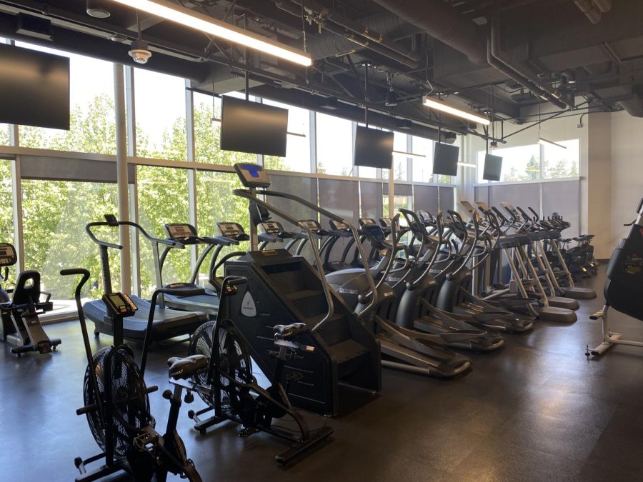 A stair master and different cycling machines are to the left of the entrance of the gym. Students can use these to work on their core and legs.