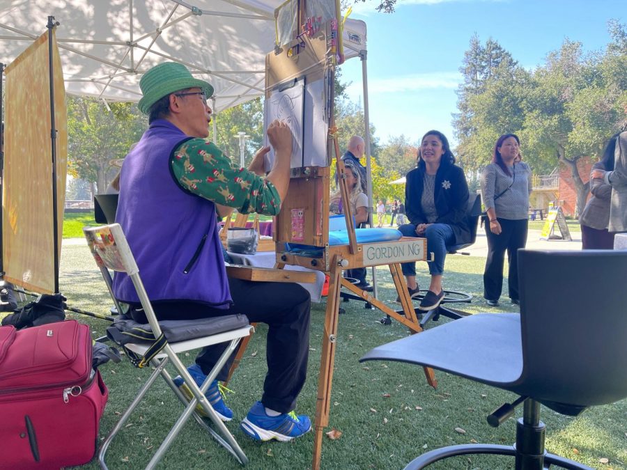 Caricature artist begins to draw a member of the Filipino American History Month kickoff event. People line up besides them to get their caricature next, on Oct 6.