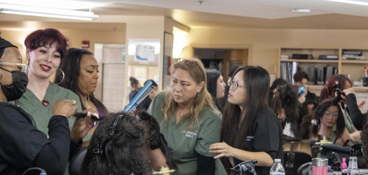 Cosmetology freshman (green scrubs) and seniors (black scrubs) get hands-on learning during the symposium.