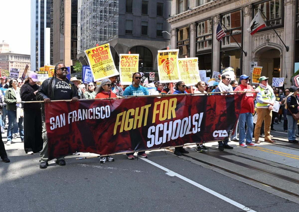 Educators march with a banner protesting the cuts to the Department of Education on May 17.