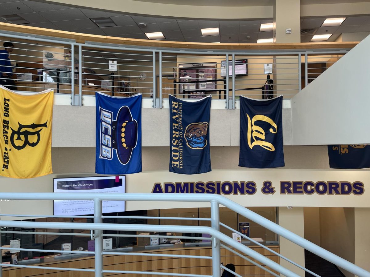 Flags from different schools hang above the Admissions and Records office in SJCC’s student center.